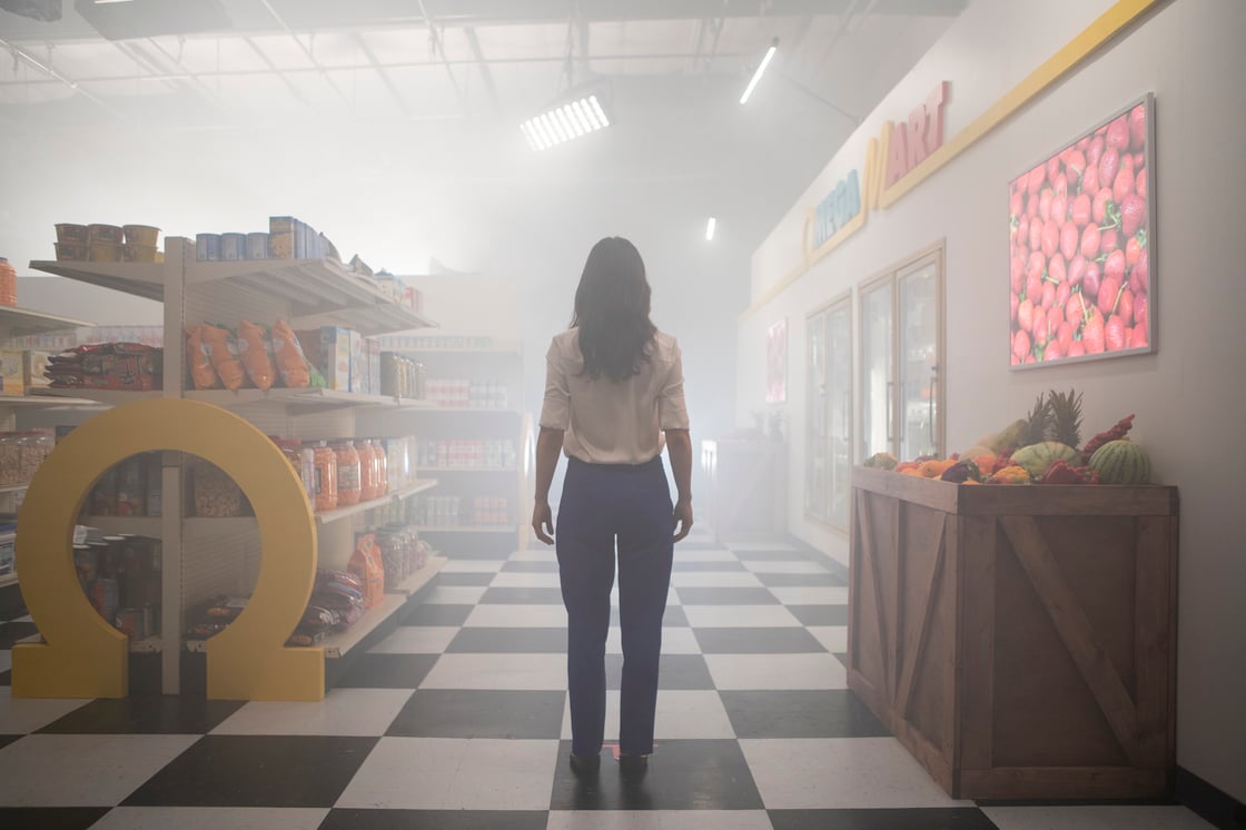 A person standing in the interior of the Omega Mart grocery store